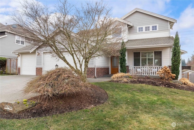 view of front of house featuring a garage, covered porch, and a front lawn