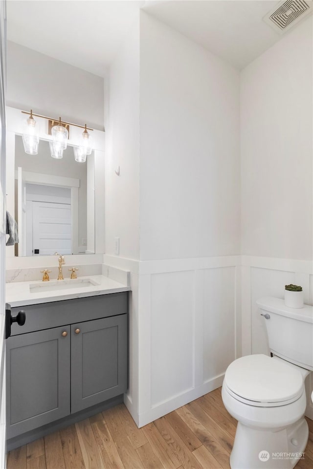 bathroom featuring vanity, wood-type flooring, and toilet