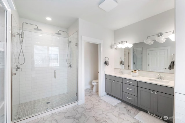 bathroom featuring vanity, toilet, and a shower with shower door