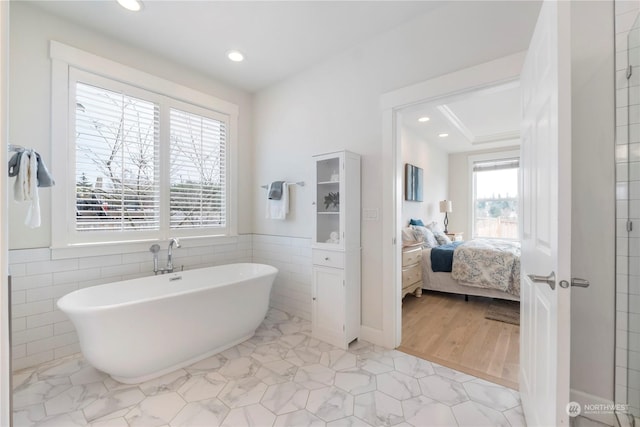 bathroom with a bathtub and tile walls