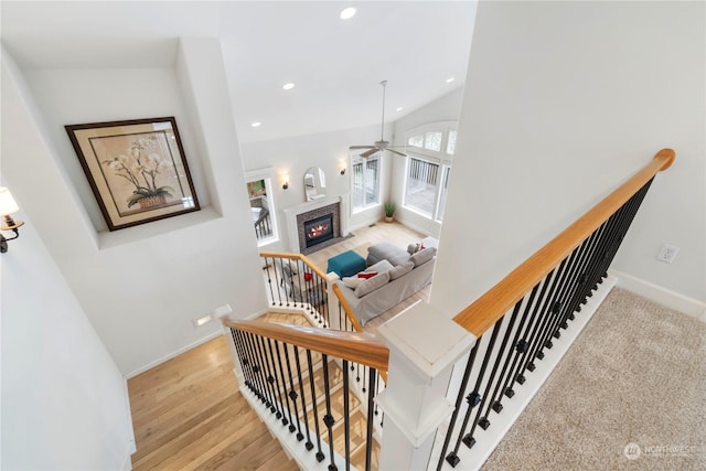 staircase featuring wood-type flooring and lofted ceiling