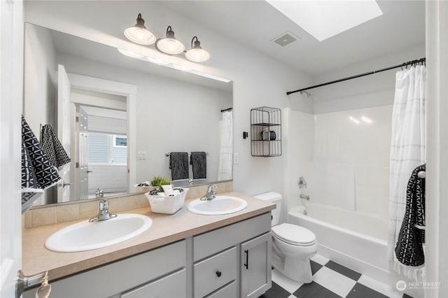 full bathroom featuring shower / bathtub combination with curtain, vanity, a skylight, and toilet