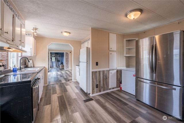 kitchen with white cabinetry, sink, stainless steel fridge, and white refrigerator