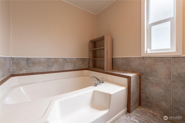 bathroom featuring tile walls and a bath