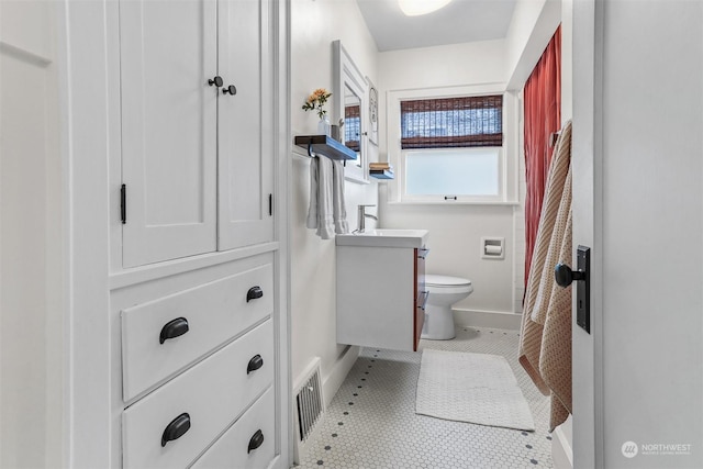 bathroom featuring tile patterned flooring, vanity, and toilet