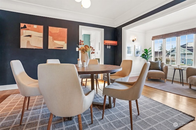 dining space featuring hardwood / wood-style flooring and ornamental molding