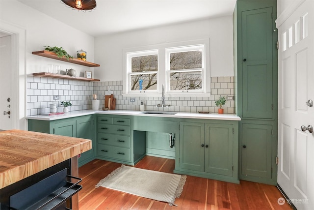 kitchen with sink, decorative backsplash, dark hardwood / wood-style floors, and green cabinetry