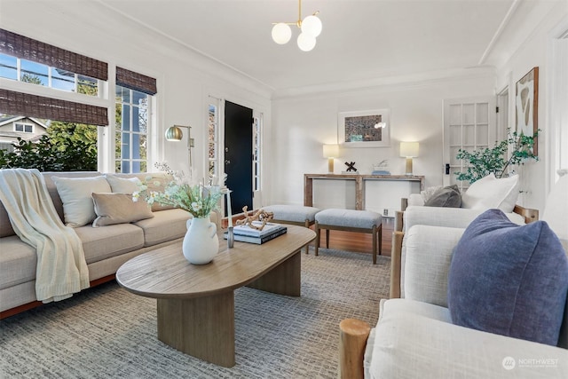 living room with crown molding and a chandelier