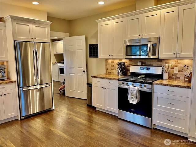 kitchen with stainless steel appliances, white cabinetry, decorative backsplash, and dark wood-style floors