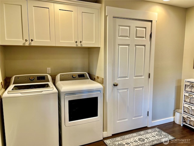 laundry area featuring dark wood-style floors, washing machine and clothes dryer, cabinet space, and baseboards