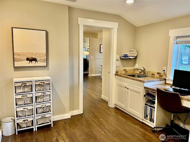 office space featuring vaulted ceiling, baseboards, dark wood finished floors, and a sink