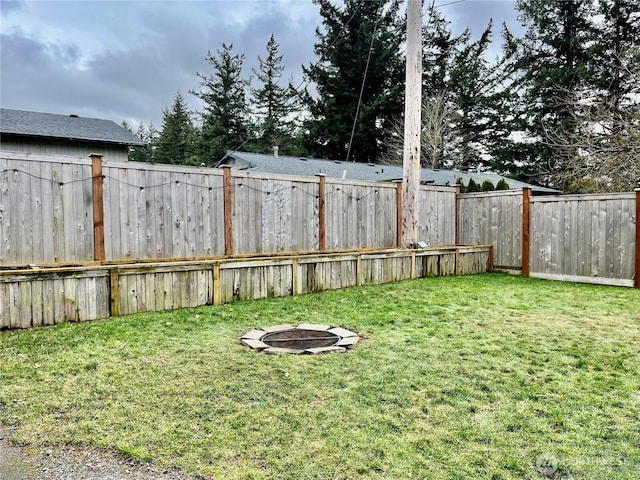 view of yard featuring a fire pit and a fenced backyard