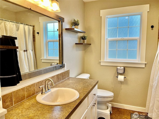 full bathroom featuring toilet, baseboards, and vanity