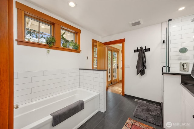 bathroom with recessed lighting, tile patterned floors, visible vents, and a garden tub