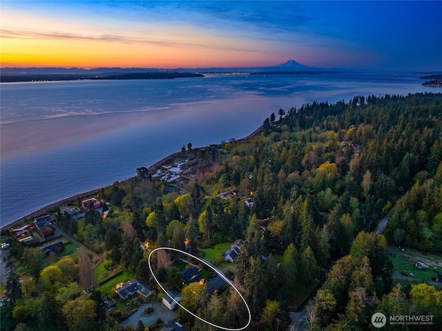 aerial view at dusk featuring a water view