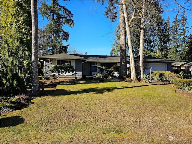 ranch-style house featuring a garage and a front lawn