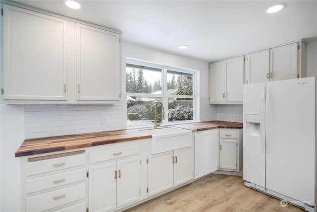 kitchen with wood counters, sink, white appliances, and white cabinetry