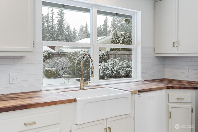 kitchen featuring sink, white cabinets, backsplash, wooden counters, and white dishwasher