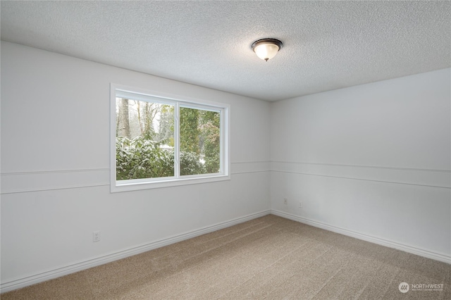 carpeted empty room with a textured ceiling