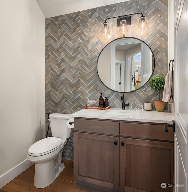 bathroom with toilet, tile walls, vanity, hardwood / wood-style flooring, and decorative backsplash