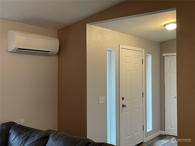 foyer entrance featuring hardwood / wood-style floors and a wall unit AC