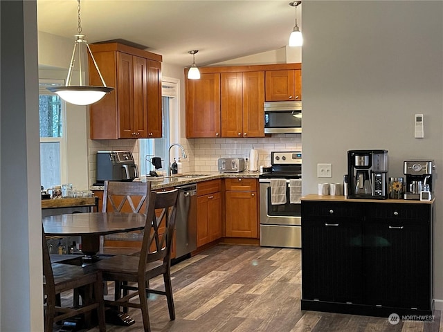 kitchen featuring stainless steel appliances, hardwood / wood-style flooring, sink, and decorative light fixtures