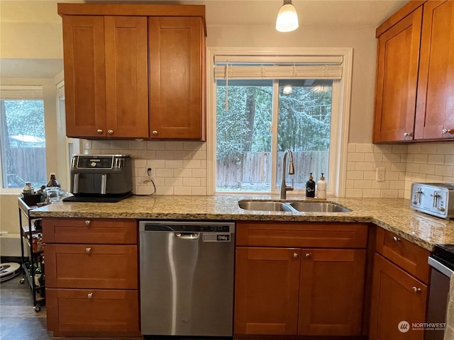 kitchen with tasteful backsplash, light stone countertops, sink, and stainless steel dishwasher