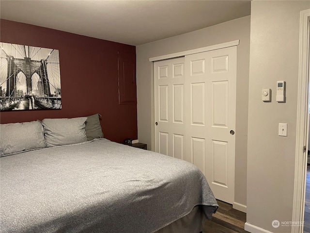 bedroom featuring dark wood-type flooring and a closet