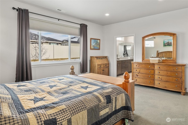 carpeted bedroom featuring connected bathroom