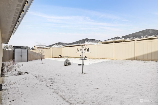 yard covered in snow featuring a storage shed