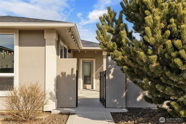 view of home's exterior with roof with shingles, a patio area, and stucco siding