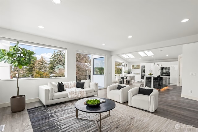 living room featuring lofted ceiling and hardwood / wood-style floors