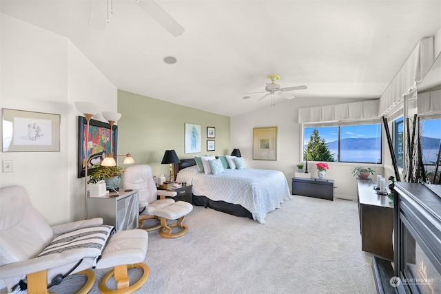 bedroom featuring light carpet, lofted ceiling, and ceiling fan