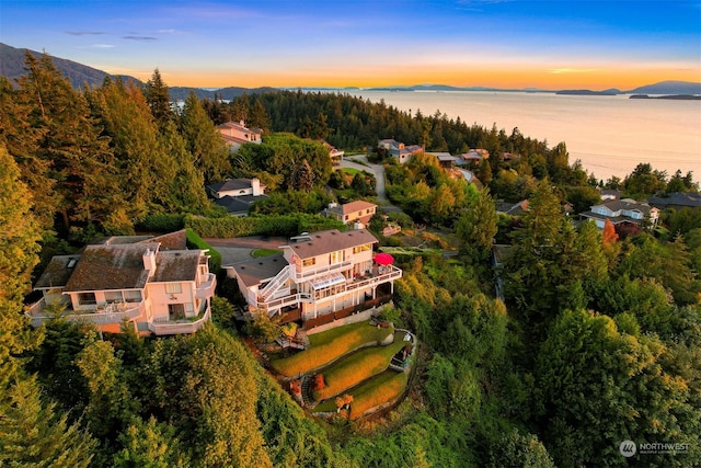 aerial view at dusk featuring a water and mountain view