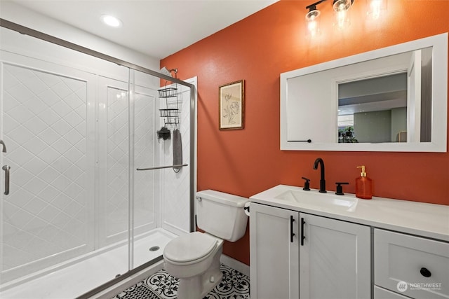 bathroom featuring vanity, tile patterned floors, a shower with door, and toilet