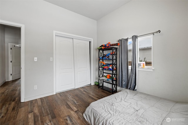 bedroom with dark wood-type flooring and a closet