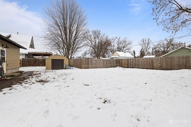 yard covered in snow with a storage shed