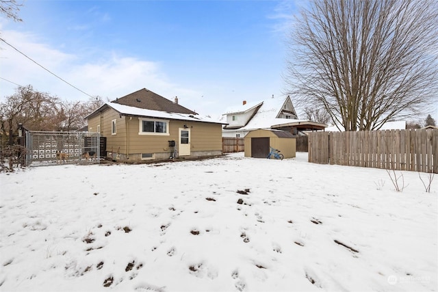 snow covered back of property with a shed