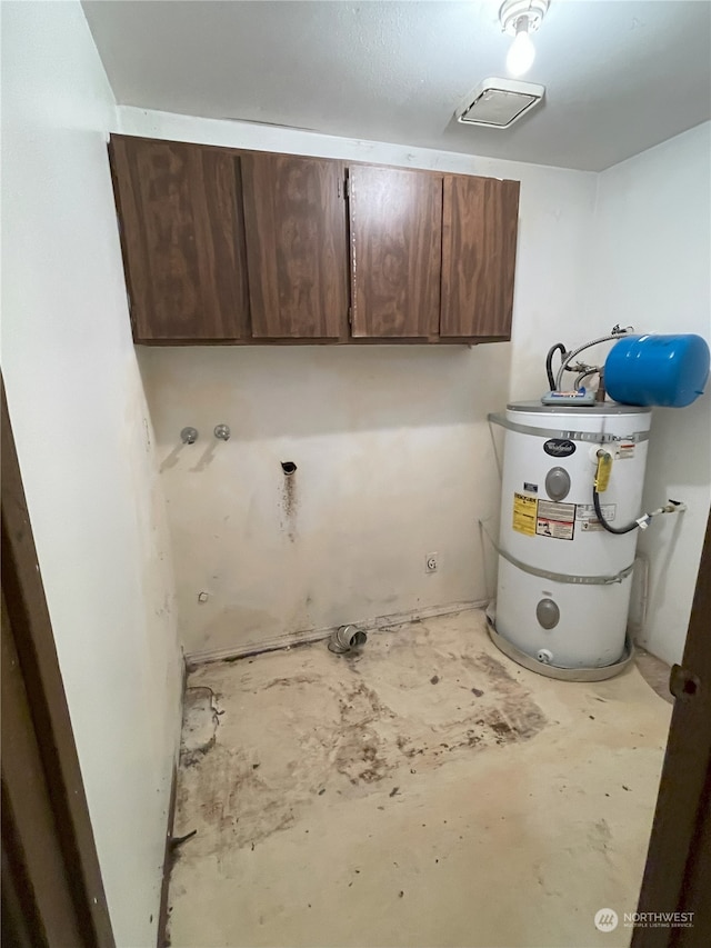 laundry room featuring cabinets and water heater