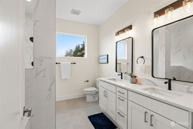 bathroom featuring a healthy amount of sunlight, toilet, and vanity