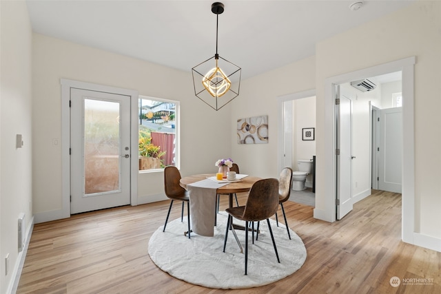 dining space featuring an inviting chandelier and light hardwood / wood-style flooring