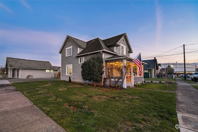 property exterior at dusk featuring an outbuilding, a garage, and a lawn