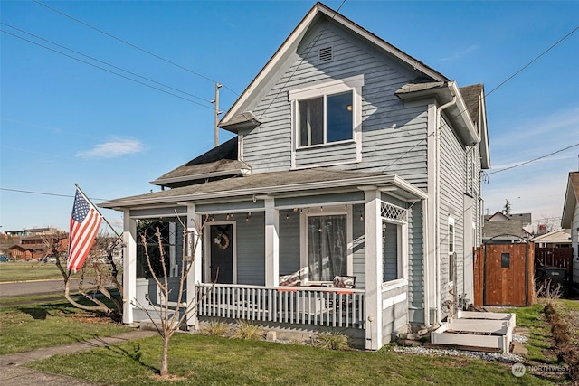 view of front of house with covered porch and a front lawn