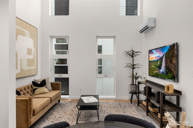 living room with a high ceiling and an AC wall unit