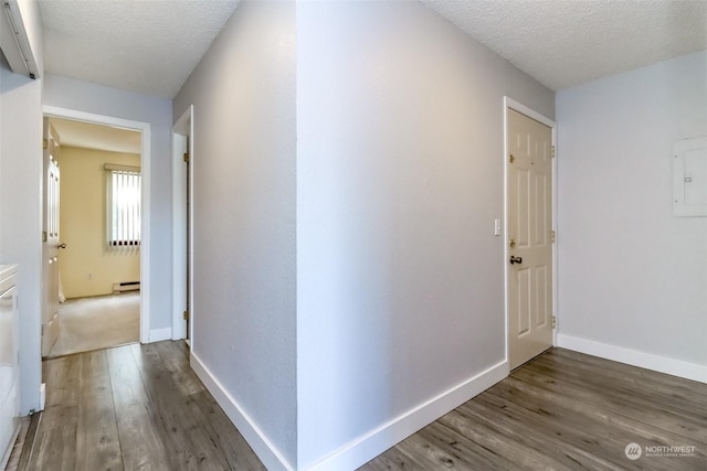 corridor with hardwood / wood-style flooring, a baseboard radiator, and a textured ceiling