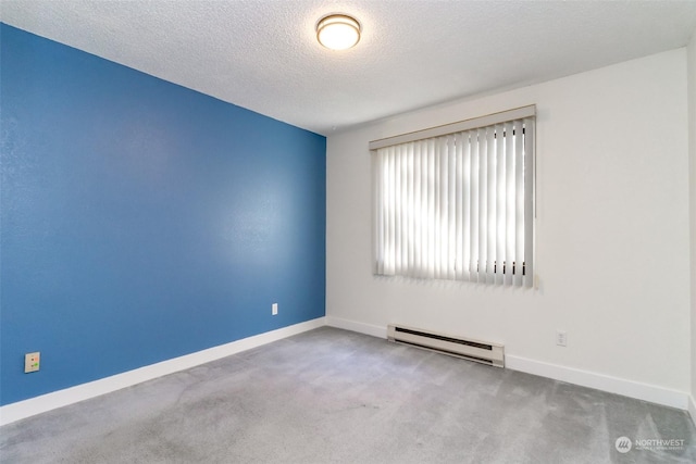 empty room with light colored carpet, a textured ceiling, and a baseboard heating unit