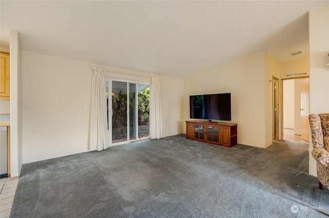 unfurnished living room featuring dark colored carpet and lofted ceiling