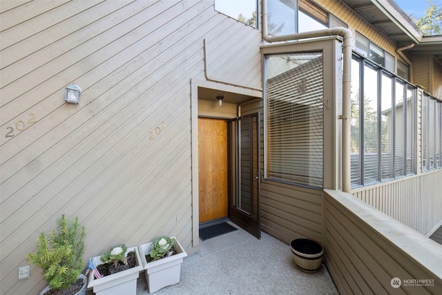 view of exterior entry with a balcony