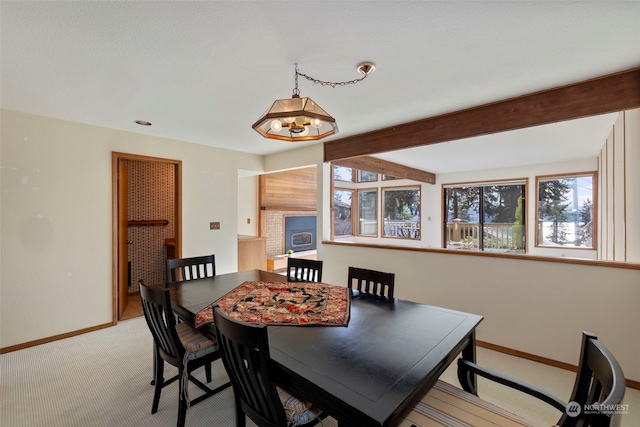 carpeted dining space featuring beam ceiling