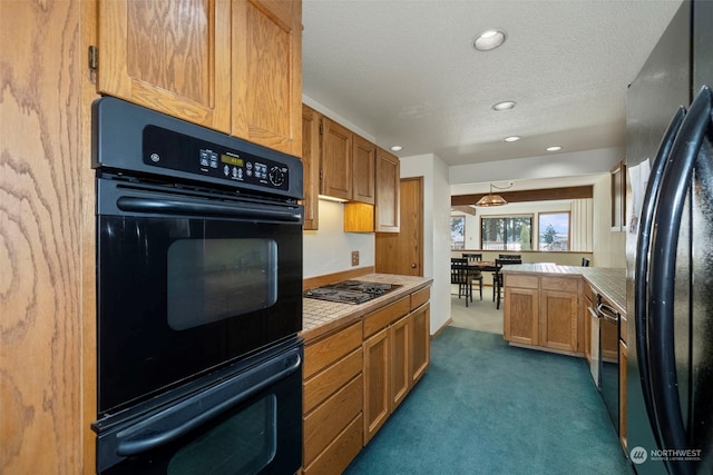 kitchen with a textured ceiling, dark carpet, and black appliances